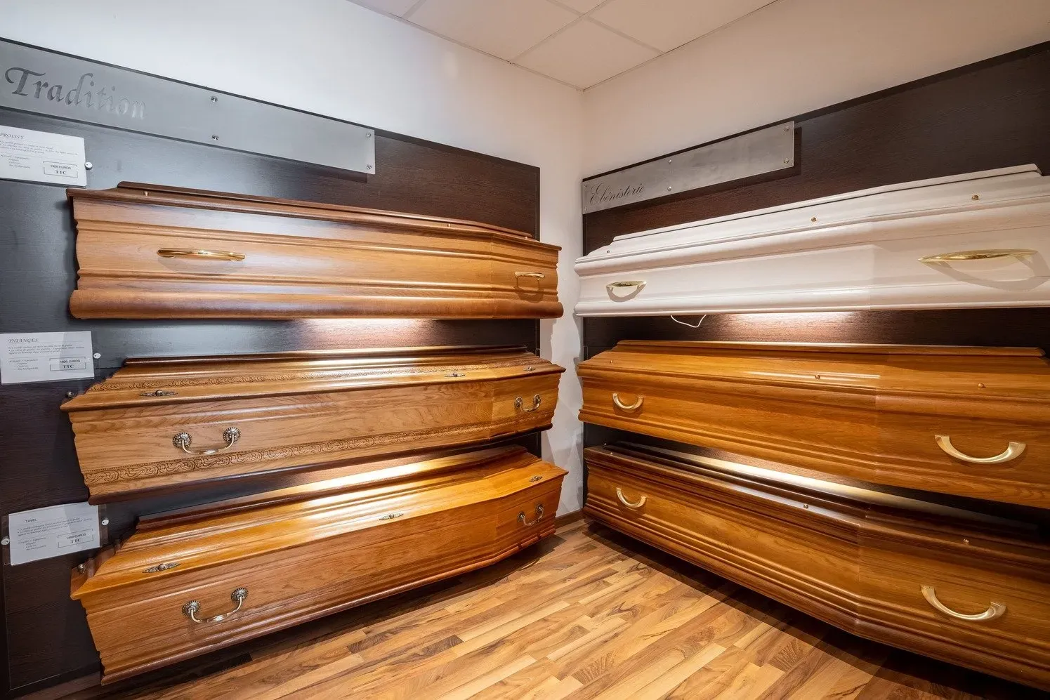 Exposition de différents modèles de cercueils en bois et en métal en boutique.