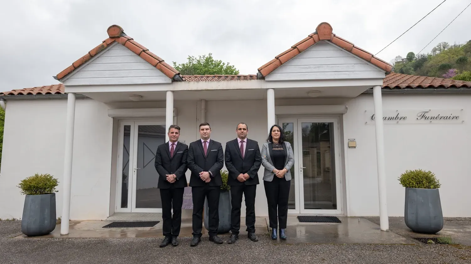 Équipe de conseillers funéraires devant l'entrée de la chambre funéraire.