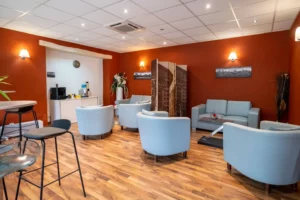 Salon d'accueil chaleureux avec fauteuils et espace détente pour les familles.
