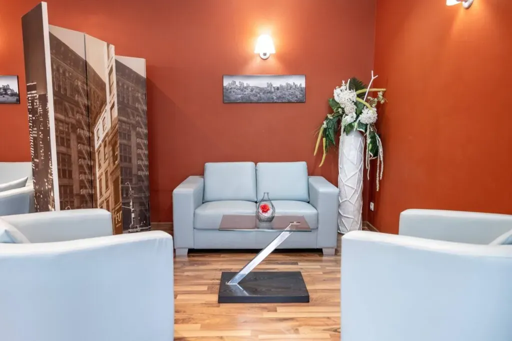 Salon d'attente et de recueillement chaleureux avec canapés et fauteuils.